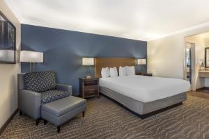 a hotel room with a bed and a chair at Best Western Town & Country Lodge in Tulare