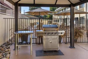 a grill on a patio with umbrellas at Best Western Town & Country Lodge in Tulare