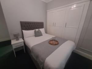 a small bedroom with a bed with a tray on it at Hotel 52 in Whitley Bay