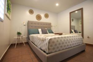 La Finca Sunset - Fajardo 1 Bed NEW في Playa de Fajardo: غرفة نوم بسرير كبير ومرآة كبيرة