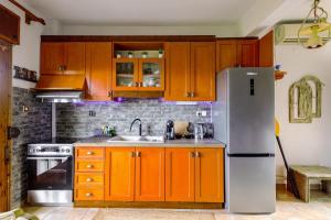 - une cuisine avec des armoires orange et un réfrigérateur blanc dans l'établissement Holiday Apartment steps from the Beach, à Ormos Panagias