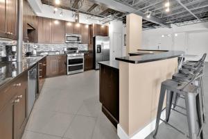 a large kitchen with a counter and stools in it at 3 BR 2 BA Downtown Loft water view in Fort Walton Beach