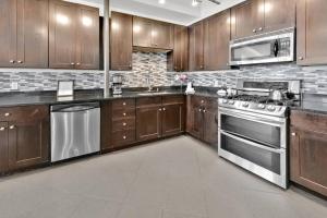 a kitchen with wooden cabinets and stainless steel appliances at 3 BR 2 BA Downtown Loft water view in Fort Walton Beach