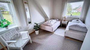 une chambre avec un lit, une chaise et des fenêtres dans l'établissement Stylish vacation home - close to sea and nature, à Hejls