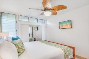 une chambre avec un lit et un ventilateur de plafond dans l'établissement Kulakane 211 · KK 211 Updated OceanFront Whale Watching, à Kahana 55 autres photos