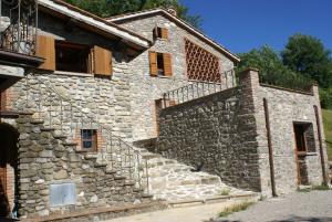 un ancien bâtiment en pierre avec un mur et des escaliers en pierre dans l'établissement Sunset Barga Toskana Kürzlich Renoviert, à Barga