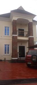 ein rotes Auto, das vor einem Haus parkt in der Unterkunft House of jessy in Iju