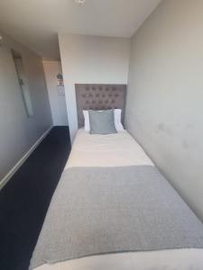 a small white room with a bed in it at Hotel 52 in Whitley Bay +4 photos