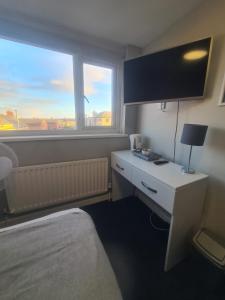 une chambre d'hôtel avec un lit, un bureau et une fenêtre dans l'établissement Hotel 52, à Whitley Bay