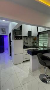 eine Küche mit weißen Schränken und einer schwarzen Arbeitsplatte in der Unterkunft House of jessy in Iju