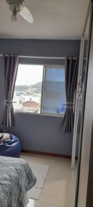 a bedroom with a window with a view of the ocean at 57m2, quarto casal, colchonete extra, super arejado in São José