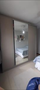 a mirror reflection of a bed in a bedroom at 57m2, quarto casal, colchonete extra, super arejado in São José