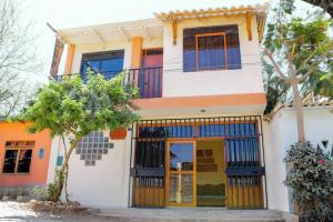 una casa arancione e bianca con una porta di Lupita House a Máncora