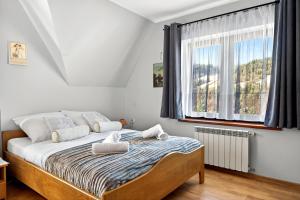 En eller flere senge i et værelse på Gut Apartment - 2 sypialnie, duża kuchnia, kino domowe NETFLIX & HBO, kryty parking, szybkie WIFI, 5km od Zakopane