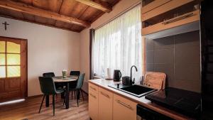 a kitchen with a table and chairs and a counter top at Domek w Murzasichlu z kominkiem in Murzasichle