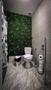 La salle de bains est pourvue d'un mur vert et de toilettes. dans l'établissement Domek w Murzasichlu z kominkiem, à Murzasichle