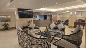 a living room with a couch and chairs and a table at Al JAWHRA TOWER HOTEL in Mecca