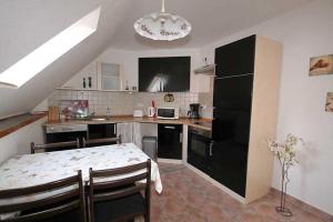 a kitchen with a table and a black refrigerator at Ferienwohnung Anna in Schwarz