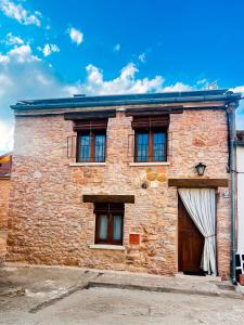un bâtiment en briques avec une porte et des fenêtres en bois dans l'établissement BocallenaRural LASTRAS DE CUELLAR, à Lastras de Cuéllar