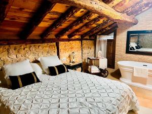 une chambre avec un grand lit et une baignoire dans l'établissement BocallenaRural LASTRAS DE CUELLAR, à Lastras de Cuéllar