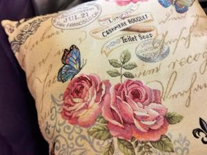 ein Kissen mit rosa Rosen und einem Schmetterling darauf in der Unterkunft Wohnung in Wilhelmsfehn mit Großem Balkon in Wiesmoor