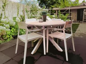 - une table et des chaises blanches dans le jardin dans l'établissement Luxe Vakantiehuis met privé Wellness, à Zuidwolde