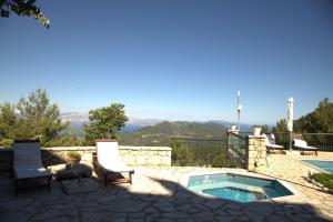 a patio with a swimming pool and chairs and a pool at Sommer Dafnopanagia Villa Magda in Káto Exánthia