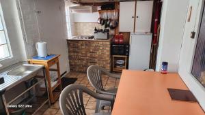 una cucina con tavolo, sedie e frigorifero di Wauquier a Mons-en-Baroeul