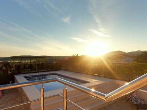 a view of the sun setting on a balcony at Modernes Ferienhaus Mit Eigenem Pool Und Meerblick in Bilice