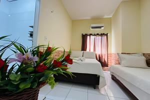 une chambre d'hôtel avec un lit, un canapé et des fleurs dans l'établissement Pousada Caminho das Águas, à Santo Amaro 73 autres photos