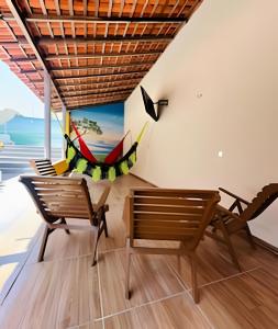 une pièce avec des chaises et un hamac accroché au mur dans l'établissement Pousada Caminho das Águas, à Santo Amaro
