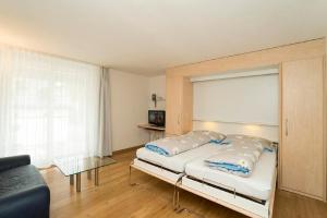 une chambre avec un lit et un canapé dans l'établissement Chesa Quadrella, à Pontresina