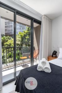 a bedroom with a bed and a balcony at Charmosos Apartamentos Reformados na Glória in Rio de Janeiro +106 photos