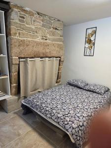 - une chambre avec un lit en face d'un mur en pierre dans l'établissement Calm and central apartment, à Quimper