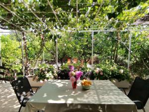 une table avec un vase de fleurs dans un jardin dans l'établissement Ferienhaus Karmen Auf Zwei Ebenen Mit Garten, à Orebić