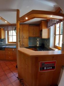 eine Küche mit Holzschränken und einer Arbeitsplatte in der Unterkunft Großzügiges Ferienhaus mit Sauna und Whirlpool in Lachtal