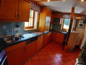 eine Küche mit Holzschränken und einer Spüle in der Unterkunft Großzügiges Ferienhaus mit Sauna und Whirlpool in Lachtal