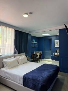 a bedroom with blue walls and a large bed at Casa Nada Hotel in Guanajuato +30 photos