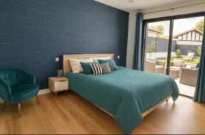 a blue bedroom with a bed and a chair at Magnifique villa SEREN avec piscine in Arcangues +8 photos