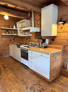 - une cuisine avec des appareils blancs et des murs en bois dans l'établissement Rugsund Handelsstad, à Rugsund