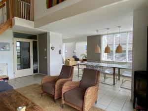 ein Wohnzimmer mit zwei Stühlen und einem Tisch in der Unterkunft Luxus-Villa, zu Fuß zum Strand, Dünenansicht mit privatem Whirlpool in Julianadorp