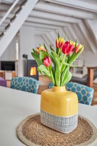 un vase jaune avec des fleurs dedans sur une table dans l'établissement Komfortables Ferienhaus In Purer Natur, à Edertal