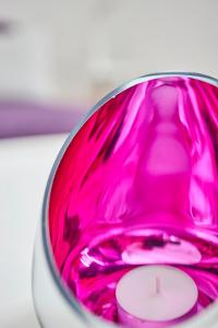 un objet en verre rose avec une bougie dans celui-ci dans l'établissement Komfortables Ferienhaus In Purer Natur, à Edertal