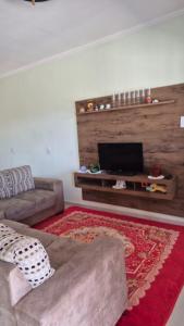 een woonkamer met een bank en een flatscreen-tv bij Chácara Nonna Rosa in Socorro