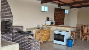 a kitchen with a brick oven and a stove at Chácara Nonna Rosa in Socorro