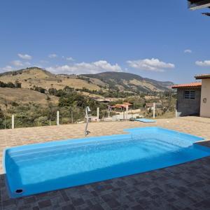 een blauw zwembad in het midden van een tuin bij Chácara Nonna Rosa in Socorro +48 foto's