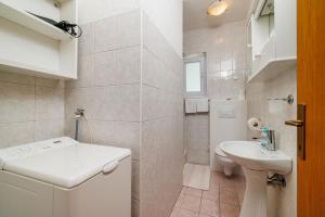 a white bathroom with a sink and a toilet at Apartments Marija in Senj +118 photos
