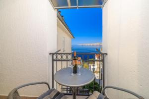 a table with a bottle of wine on a balcony at Apartments Marija in Senj