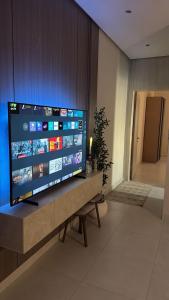 una grande TV a schermo piatto seduta su un tavolo in una stanza di شقة الفيصلية a Gedda Altre 2 foto