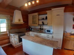 eine Küche mit weißen Schränken und einer großen Insel in der Unterkunft Ferienhaus für 8 Personen ca 210 m in Lachtal, Steiermark Obersteiermark in Lachtal + 24 Fotos